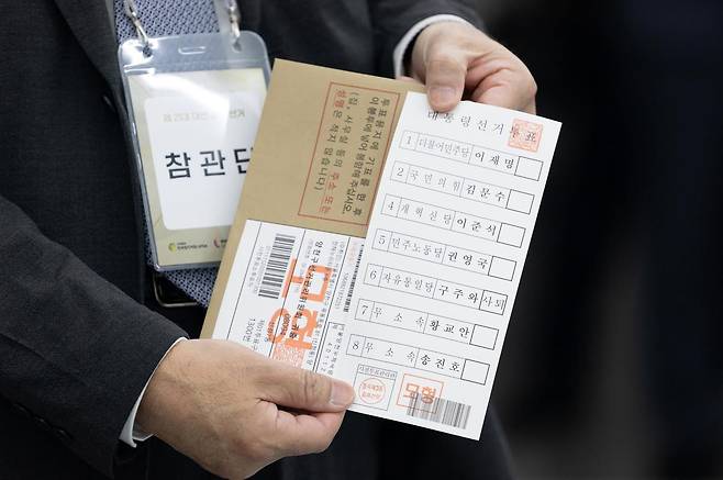 제21대 대통령 선거 사전투표를 하루 앞둔 28일 서울 광진구 중곡3동 주민센터에 마련된 사전투표소에서 투표 참관단이 인쇄된 투표용지를 들어보이고 있다. 2025.05.28. 사진공동취재단