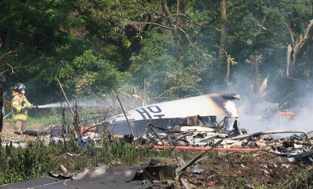 29일 오후 1시 49분쯤 경북 포항시 남구 동해면 신정리 공터에 해군 초계기가 추락한 가운데 소방관이 화재를 진압하고 있다. 포항=연합뉴스