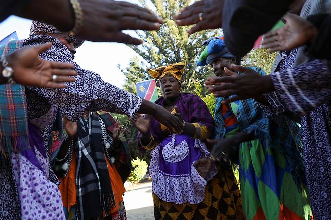28일(현지시간) 나미비아 빈트후크에서 처음 열린 ‘나미비아 제노사이드(집단학살)’의 국가 추모식에서 참석자들이 희생당한 헤레로족의 전통 의상을 입고 노래를 부르고 있다. 로이터연합뉴스