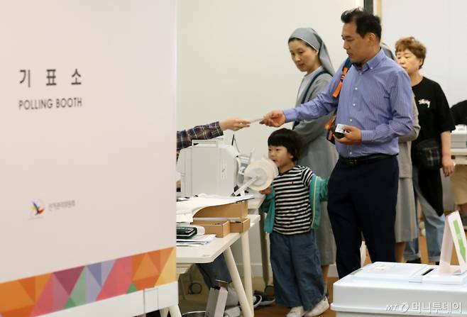 제21대 대통령선거 사전투표 첫 날인 29일 오전 서울 중구 명동주민센터에 마련된 투표소에서 한 시민이 아이와 함께 소중한 한 표를 행사하고 있다. 2025.5.29/사진=뉴스1 Copyright (C) 뉴스1. All rights reserved. 무단 전재 및 재배포, AI학습 이용 금지. /사진=(서울=뉴스1) 오대일 기자