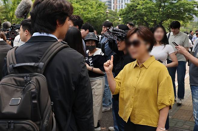 개혁신당 이준석 대선 후보가 지난 28일 서울 여의도 여의도공원에서 유세를 마치고 백브리핑을 하는 도중 한 시민으로부터 이 후보가 전날 토론회에서 여성 신체를 묘사하며 젓가락 발언을 한 것에 대한 항의를 받고 있다. 뉴시스