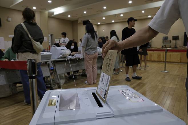 관외 사전투표를 마친 유권자가 기표한 투표지를 회송용 봉투에 넣고 봉함해 투표함에 넣고 있다. 김명진 기자