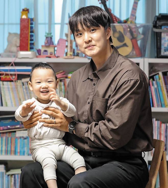 지난 26일 오후 인천의 한 아파트에서 소아암, 희소 질환이 있는 아이들의 소원을 들어주는 유튜버 이도열(오른쪽)씨가 뇌병변을 앓는 김다니엘군을 무릎에 앉히고 포즈를 잡았다. 이날 이씨는 자주 넘어지는 다니엘에게 푹신한 거실 매트를 선물했다. /박성원 기자