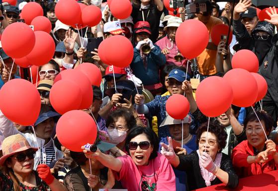 국민의힘 지지자들이 30일 충북 충주시 젊음의 거리에서 빨강 풍선을 들고 ‘외박유세’에 나선 김문수 대선후보의 연설을 듣고 있다. 임현동 기자