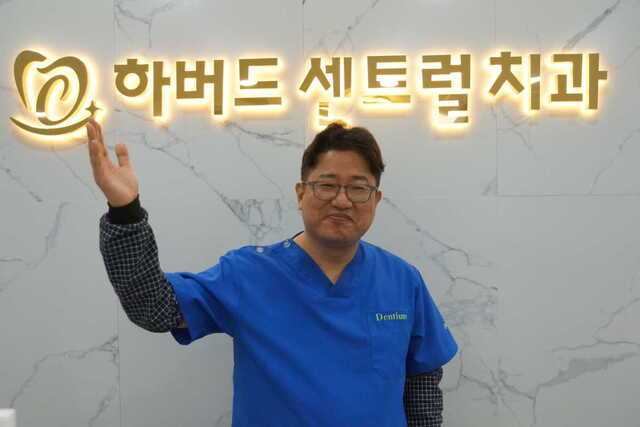 정동수 하버드센트럴치과 원장이 최근 부산 사상구 병원 입구 로고 앞에서 기념 촬영을 하고 있다.