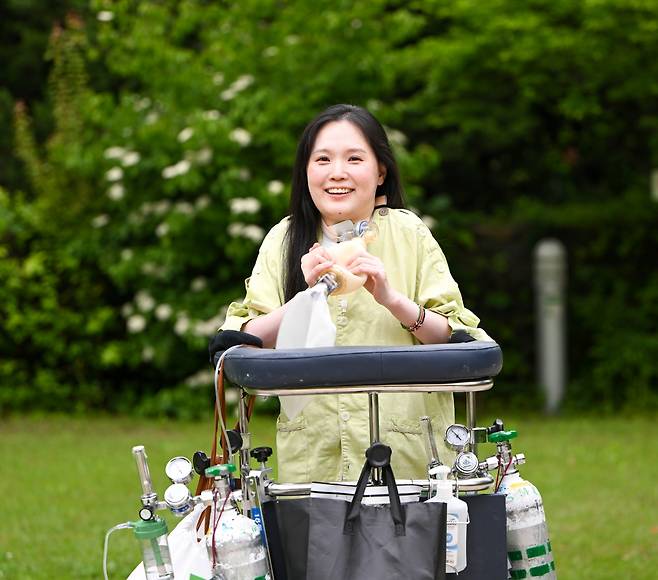 김온유 작가가 최근 서울 강남구 한 종합병원 내 산책로에서 앰부(수동식 인공호흡기)를 잡고 밝은 미소를 보이고 있다. 신석현 포토그래퍼