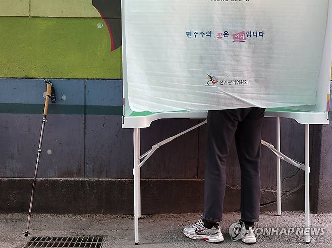 '몸은 불편해도 포기할 수 없는 한 표' (서울=연합뉴스) 김도훈 기자 = 제21대 대통령 선거 사전투표 첫날인 29일 서울 중구 소공동주민센터에 설치된 사전투표소에서 거동이 불편한 유권자가 기표소에서 투표를 하고 있다. 2025.5.29 superdoo82@yna.co.kr