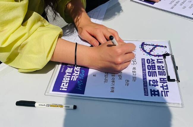 한 유권자가 지난달 13일 서울 서대문구 신촌역 인근에서 열린 ‘성평등 정치로 가는 페미니스트 공동행동’ 전국 캠페인 선포식에서 성평등 투표 선언문을 작성하고 있다. 한국여성단체연합 제공