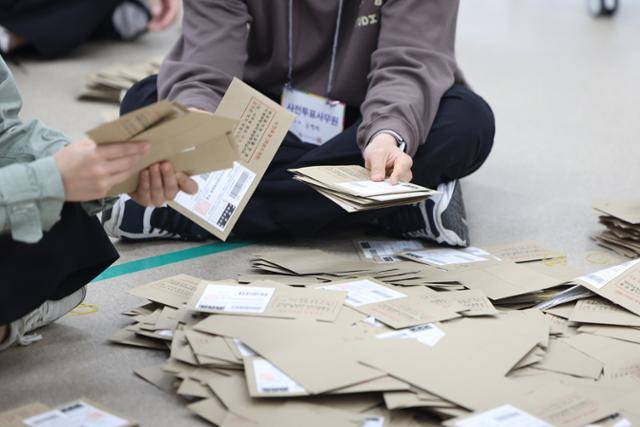 기사와 직접 관련 없음. 사전투표사무원들이 참관인 및 공정선거참관단이 지켜보는 가운데 관외투표함을 열어 투표용지 분류 작업을 하고 있다. 연합뉴스