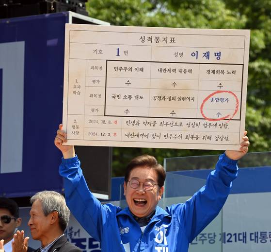1일 경북 안동시 동부동 웅부공원에서 열린 이재명더불어민주당 대선후보의 유세에서 초등학교 은사로부터 이후보를 평가한 가상의 성적표를 전달받은 후보자가 밝게 웃으며 성적표를 들어보이고 있다. 김성룡 기자