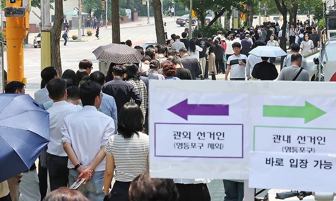 제21대 대통령선거 사전 투표일인 5월 29일 서울 영등포구 여의동주민센터에 마련된 사전투표소를 찾은 유권자들이 점심시간 중 투표를 하기 위해 긴 줄을 서고 있다. 뉴스1