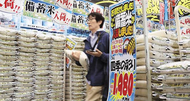 1일 일본 도쿄의 한 마트를 찾은 시민이 정부가 방출한 비축미 포대를 들고 있다. /AFP 연합뉴스