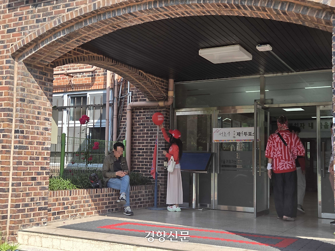 빨간색 옷을 입은 여성이 3일 서울 서초구 윤석열 전 대통령 사저 인근 투표소에서 ‘대통령 김문수’라고 적힌 풍선을 두고 있다. 우혜림 기자