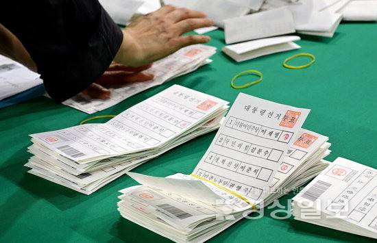 ▲ 개표 사무원들이 투표용지를 정리하고 있다.