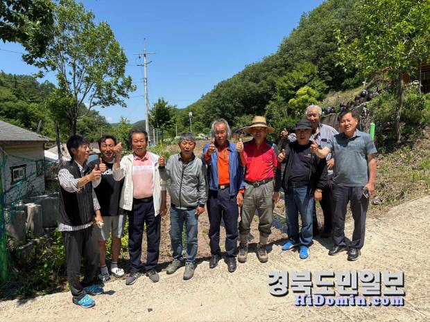 이재명 대통령의 생가터 앞에서 도촌리 주민들이 "이재명 대통령" 이라는 구호와 함께 엄지를 치켜들며 단체사진을 촬영하고 있다. 사진=유상현 기자.
