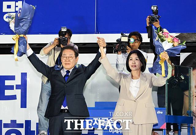 제21대 대통령 당선이 확실시 되는 이재명 더불어민주당 대선 후보가 4일 서울 여의도 국회 정문 앞에 마련된 개표방송 야외무대에서 김혜경 여사와 함께 인사를 하고 있다. /국회=배정한 기자