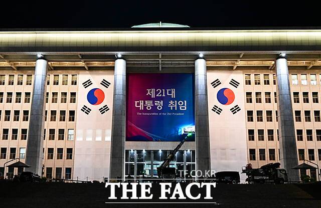 이재명 더불어민주당 대선 후보가 제21대 대통령으로 당선된 4일 오전 서울 여의도 국회 외벽에 태극기와 취임 축하 현수막이 설치되고 있다./국회=배정한 기자