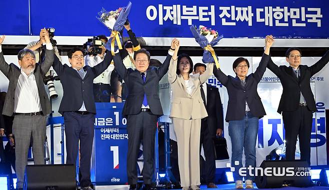 제21대 대통령 선거 당선이 확실시 된 이재명 더불어민주당 후보가 4일 새벽 서울 여의도 의사당대로에서 열린 국민 개표방송 행사에서 지지자들을 향해 손 흔들고 있다. 김민수기자 mskim@etnews.com