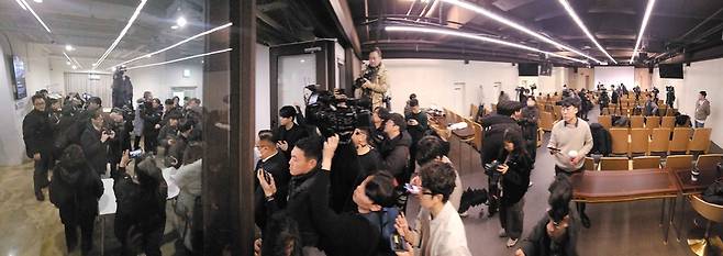 지난해 12월26일 김용현 전 국방부 장관 변호인단이 연 기자회견에서 출입이 막힌 기자들(왼쪽)이 항의하고 있다. 출입이 허용된 기자들이 바깥 상황을 지켜보고 있다. /공동취재