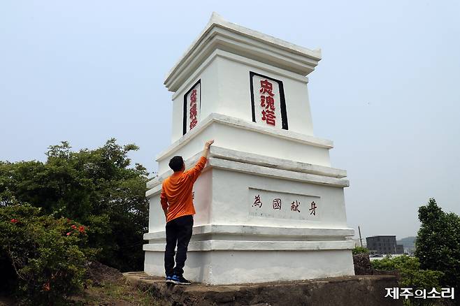 충혼탑 크기를 가늠해볼 수 있게 팔을 뻗어보이고 있는 강태권 대정역사문화연구회 사무국장. ⓒ제주의소리