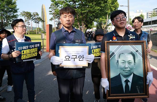 엄길용 공공운수노조 위원장, 유족, 태안화력발전소 사고 대책위 관계자들이 6일 서울 용산 대통령실 청사 인근 전쟁기념관 앞에서 사고 희생자 고(故) 김충현 씨와 관련해 강훈식 대통령비서실장에게 요구 서한 전달하기 위해 이동하고 있다. 연합뉴스