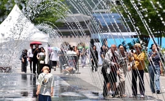절기상 망종에 초여름 날씨가 이어진 5일 오후 서울 종로구 광화문광장 분수터널에서 어린이가 무더위를 식히고 있다. 사진=뉴시스