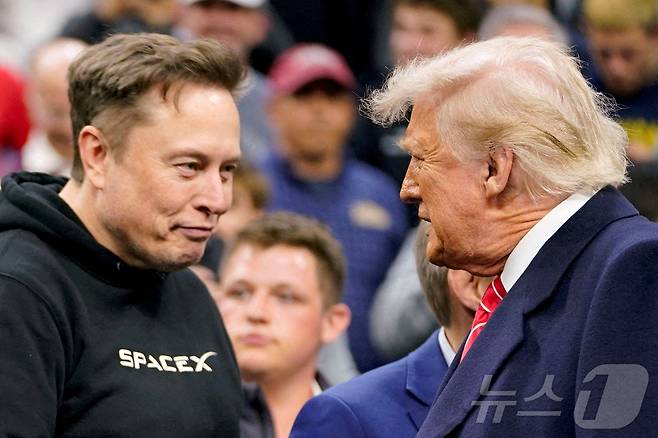 일론 머스크 테슬라 최고경영자(CEO)가 2025년 3월 22일 미국 펜실베이니아주 필라델피아에서 열린 NCAA 남자 레슬링 챔피언십에 참석한 도널드 트럼프 미국 대통령을 맞이하고 있다. 머스크 CEO는 5월28일 소셜미디어에 자신이 "오늘밤부터 업무 정리를 시작할 것"이라면서 트럼프 행정부를 떠날 것을 밝혔다. 2025.03.22. ⓒ 로이터=뉴스1 ⓒ News1 권영미 기자