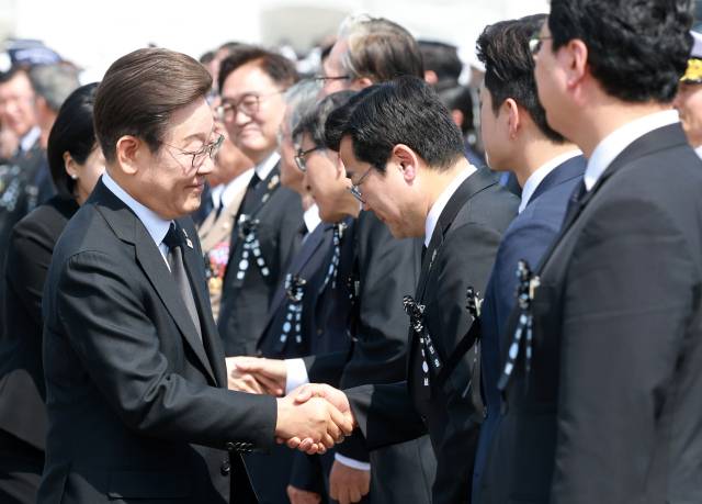 이재명 대통령이 6일 서울 동작구 국립서울현충원에서 열린 70회 현충일 추념식에서 더불어민주당 박찬대 당 대표 권한대행 겸 원내대표과 인사하고 있다. 연합뉴스