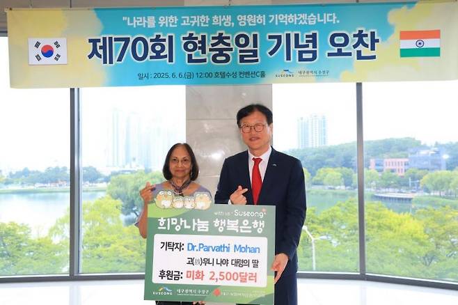 대구 수성구를 방문한 나야 대령 딸 모한 박사(왼쪽)가 어린이들을 위해 사용해달라며 2500달러는 기부한 뒤 김대권 수성구청장과 기념촬영을 하고 있다.