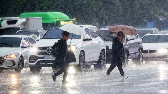 비가 내린 지난달 16일 서울 광화문사거리에서 시민들이 우산을 쓴 채 이동하고 있다. 연합뉴스