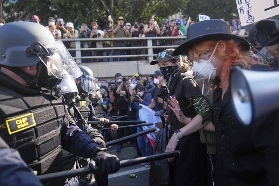 8일(현지시간) 미국 캘리포니아주 로스앤젤레스 101번 고속도로에서 정부의 강경 이민 단속에 항의하는 시위대와 이를 막는 경찰이 대치하고 있다. AP=연합뉴스