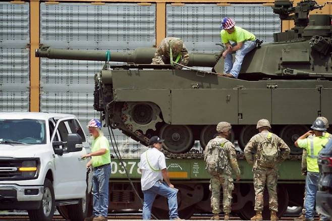 군인들과 직원들이 미국 육군 창립 250주년 열병식에서 사용될 중장비와 군용 차량을 하역하기 위해 일하고 있다. 로이터연합뉴스