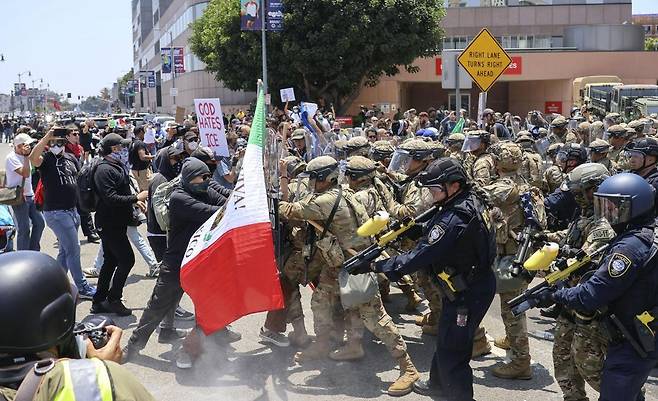8일 미국 캘리포니아주 로스앤젤레스에서 대규모 불법 이민자 단속에 항의하는 시위대와 주 방위군이 대치하고 있다. 도널드 트럼프 대통령은 이날 1992년 폭동 후 33년 만에 로스앤젤레스에 주 방위군을 투입해 시위대 진압에 나섰다. 그는 500명의 해병대원 배치도 추가로 고려하고 있다고 밝혔다. 게티이미지