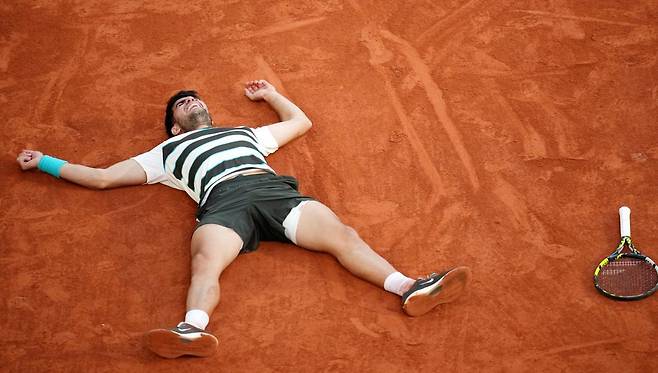 카를로스 알카라스(스페인)가 9일 끝난 프랑스오픈 남자 단식 결승에서 5시간 29분에 걸친 혈투 끝에 얀니크 신네르(이탈리아)를 꺾고 우승한 뒤 대회 메인 코트인 필리프샤트리에 코트 바닥에 누워 있다. 파리=AP 뉴시스