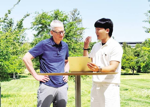 한가온씨가 8일(현지시간) 미국 캘리포니아주 쿠퍼티노 애플 본사 야외무대에서 팀 쿡 최고경영자에게 자신이 개발한 앱을 설명하고 있다. 연합뉴스