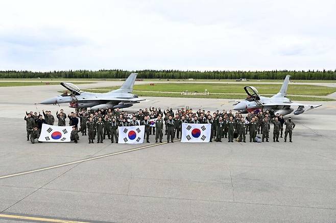 지난 4일(현지시각) 미국 알래스카주 아일슨 기지에 도착한 공군 장병들이 성공적인 훈련을 다짐하며 케이에프(KF)-16 전투기 앞에서 단체 사진을 찍고 있다. 공군 제공