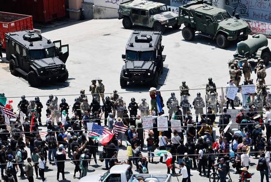 10일(현지시간) 미국 로스앤젤레스 연방청사 앞에서 시위대와 대치하고 있는 주방위군과 경찰들. AFP=연합뉴스