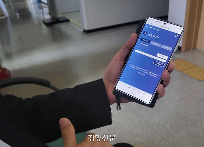 A변호사가 9일 서울중앙지법에서 서울지방변호사회 앱의 복대리 중개 기능을 보여주며 설명하고 있다. 김태욱 기자