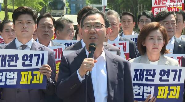 ▲주호영 국민의힘 의원이 11일 서울 서초동 서울중앙지법 앞 현장 의원총회에서 이재명 대통령의 공직선거법 파기환송심 재판부에 이어 대장동 재판부도 재판을 무기한 연기하자 사법부 스스로 독립을 못지키고 권력에 아부한다고 규탄하고 있다. 사진=국민의힘TV 영상 갈무리