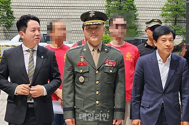 '채상병 순직 사건'과 관련해 항명 혐의를 받는 박정훈 전 해병대 수사단장(대령)이 13일 서울고법에서 열린 항소심 첫 공판기일에 참석한 후 취재진 앞에 서 있는 모습. 사진 왼쪽은 임태훈 군인권센터 소장, 오른쪽은 이성윤 더불어민주당 의원. ⓒ데일리안 진현우 기자