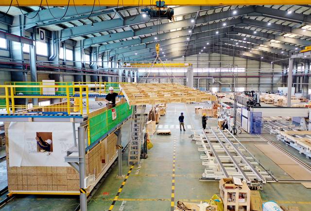 지난달 25일 충남 당진시 자이가이스트 공장에서 자동화시스템 공정을 통해 제작된 목조 모듈러 주택 구조물 간 조립이 진행되는 동안 직원들이 투습방수지 부착 등의 작업을 하고 있다. 윤성호 기자
