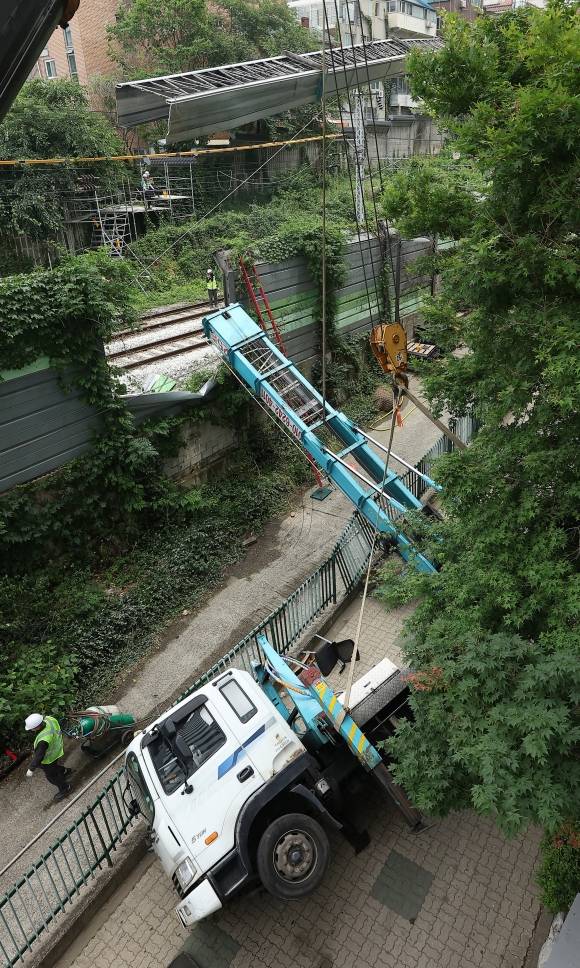 계속되는 경의중앙선 복구 작업 - 13일 서울 서대문구 경의중앙선 가좌역∼신촌역 구간 선로 위로 사다리차가 넘어져 관계자들이 복구 작업을 하고 있다. 이 사고로 전기공급 장애가 발생, 열차 운행이 지연됐다가 5시간 만에 재개됐다. 연합뉴스