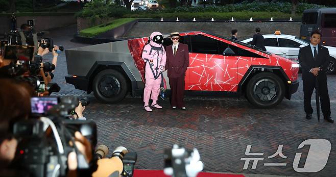 빅뱅 지드래곤(GD,권지용)이 13일 오후 서울 용산구 그랜드 하얏트 서울 호텔에서 열린 '피스마이너스원 프리미엄 하이볼 론칭 파티-더 시그널(THE SIGNAL)' 참석을 위해 PEACEMINUSONE 로고가 새겨진 사이버트럭에서 하차해 우주인과 포즈를 취하고 있다. ⓒ News1 권현진 기자