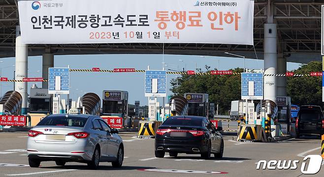 인천 영종·인천대교를 이용하는 지역주민들에 대한 통행료 무료화 및 인천국제공항고속도로 통행료 인하가 시행된 1일 오전 인천공항고속도로 톨게이트에 통행료 인하 플래카드가 걸려 있다.2023.10.1/뉴스1 ⓒ News1 박정호 기자