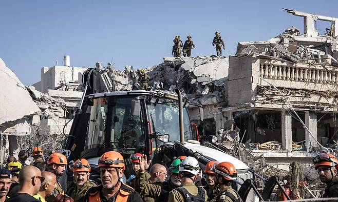 14일(현지시각) 이란에서 발사된 미사일에 폭격을 당한 이스라엘 텔아비브 남쪽 현장에서 이스라엘 긴급구조대가 구조 활동을 벌이고 있다. AFP 연합뉴스
