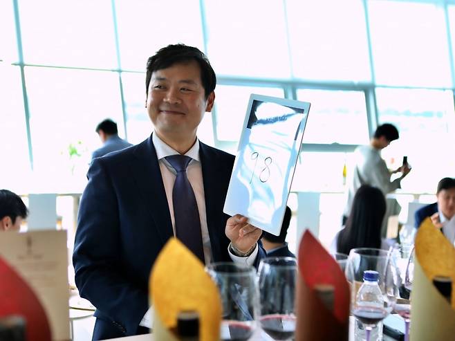 김경문 마스터 소믈리에가 와인을 시음한 뒤 점수를 매기고 있다. / 사진=롯데백화점 제공