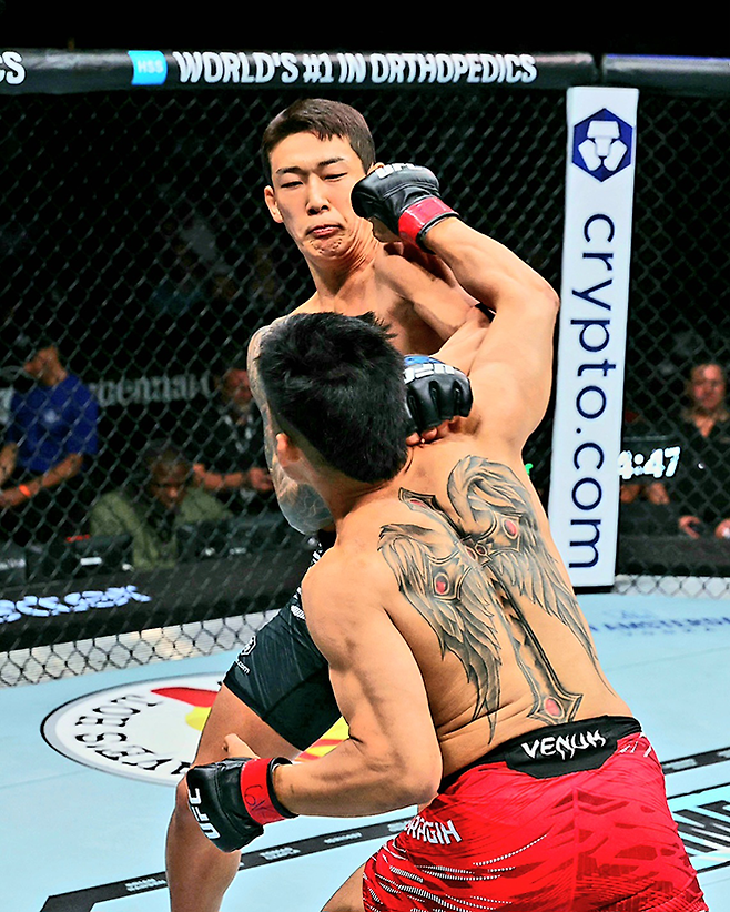 유주상이 2025년 6월 미국 뉴저지주 뉴어크 프루덴셜 센터 UFC 316 제3경기 제카 사라기를 KO 시키고 있다. 오른쪽 시계는 1라운드 종료까지 4분 47초나 남은, 즉 시작 13초 만에 레프트 카운터 훅을 적중시키는 장면이라는 것을 알게 한다. 사진=TKO