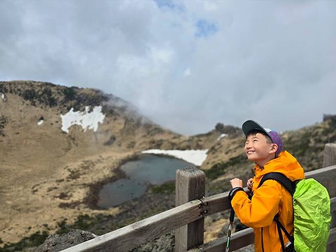궂은 날씨에 보이지 않던 한라산 백록담이 한순간 하늘이 맑아지면서 시야에 들어오자 아들 서진이가 활짝 웃고 있다. 박준형 제공