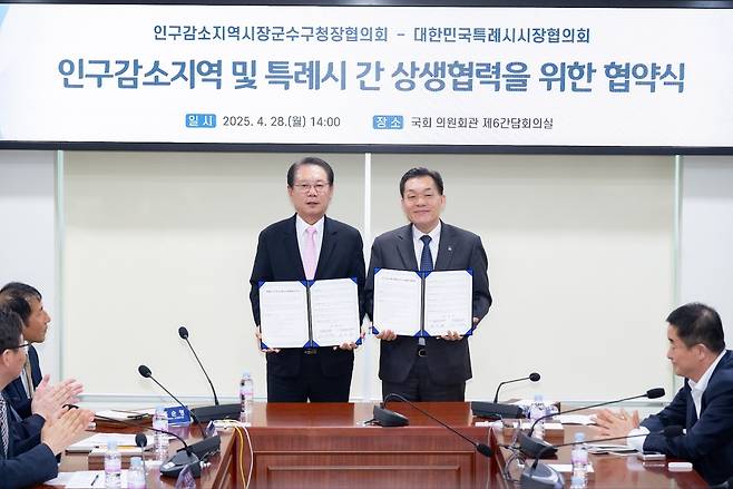 지난 4월 28일 이재준 수원시장(당시 대한민국특례시시장협의회장)과 송인헌 괴산군수(인구감소지역 시장·군수·구청장협의회장)가 국회 의원회관에서 상생협력서에 서명한 뒤 기념촬영을 하고 있다. 수원시 제공