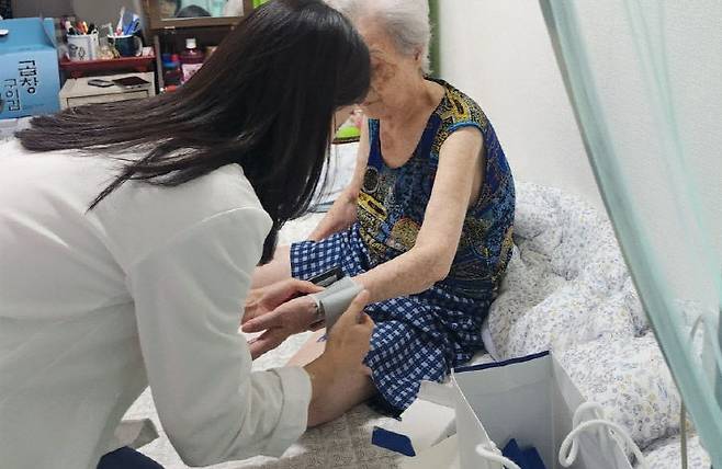 이날 보건 전문가가 지역주민 혈압을 측정 중인 모습. 사진=한국마사회 제공.